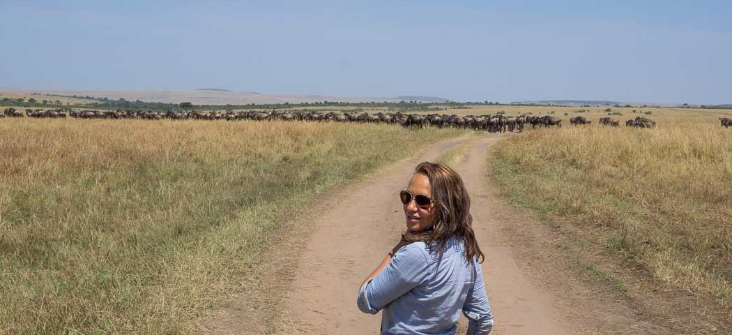 Frau vor Gnuherde in der Masai Mara während einer Kenia Safari Reise